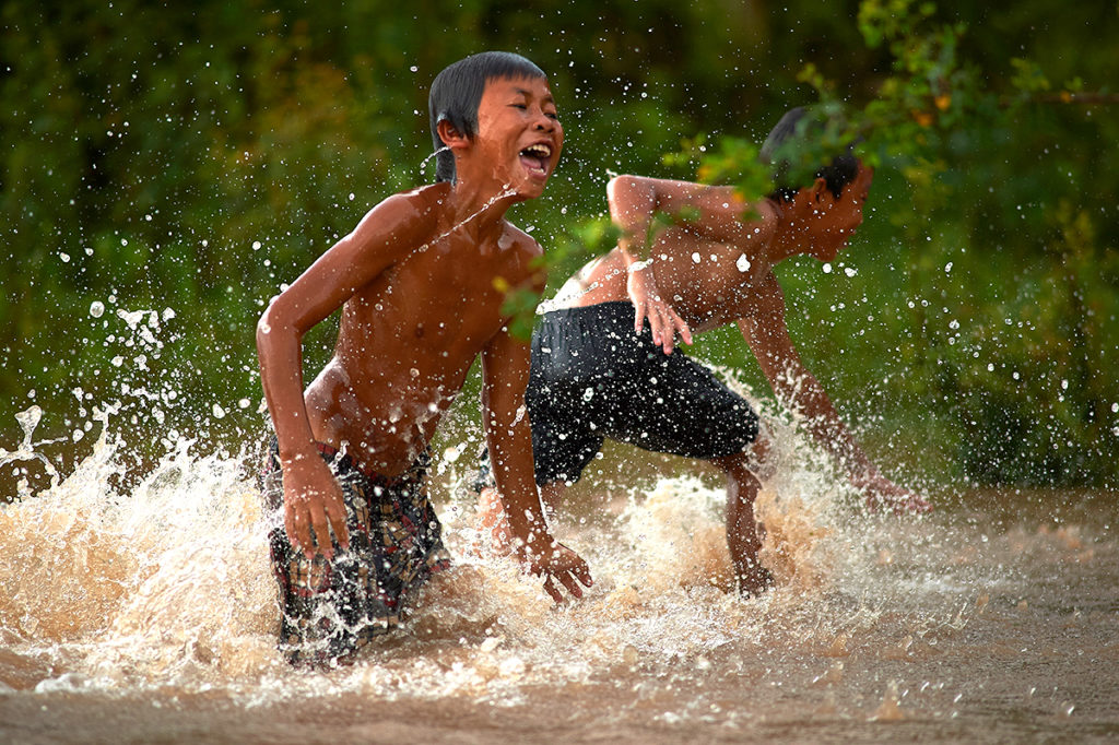 kids enjoy swimming in Mekong river